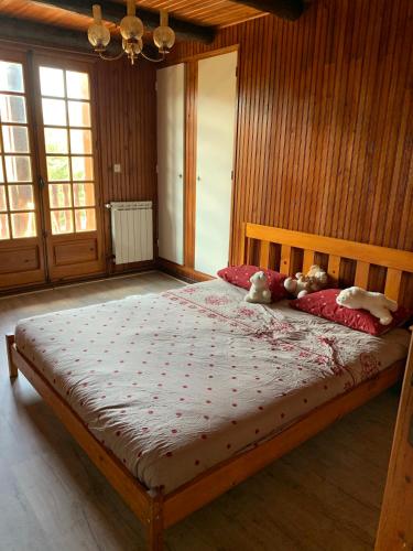 a bedroom with a large bed with two stuffed animals on it at L'ânon d'Andon in Andon