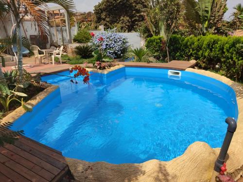 a swimming pool in a backyard with a blue pool at Residence Jardin Tropical in Yaoundé