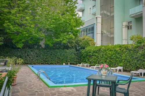 una pequeña piscina con una mesa y una sidra de mesa en Hotel Stradiot, en Rímini
