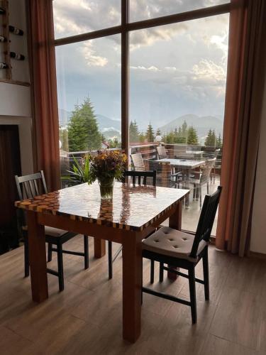 皮亞特拉芬特奈里的住宿－Tihuța Retreat，餐桌、椅子和大窗户