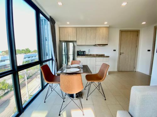a kitchen and dining room with a table and chairs at Sea Zen Condominium Bang Saray in Bang Sare