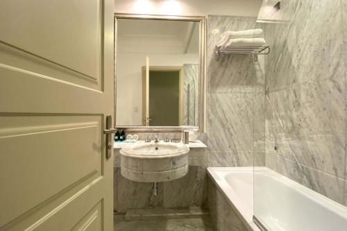 a bathroom with a sink and a tub and a mirror at BB Hotels Smarthotel Bailey's in Rome