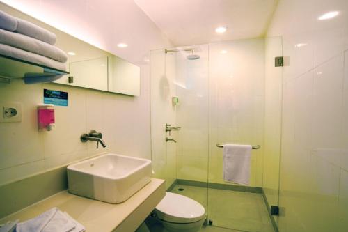 a bathroom with a sink and a toilet and a shower at Idoop Hotel by Prasanthi in Mataram