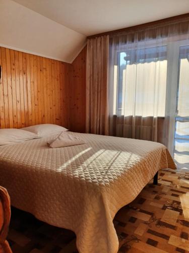 een slaapkamer met een groot bed en een raam bij Затишок в Карпатах in Slavske