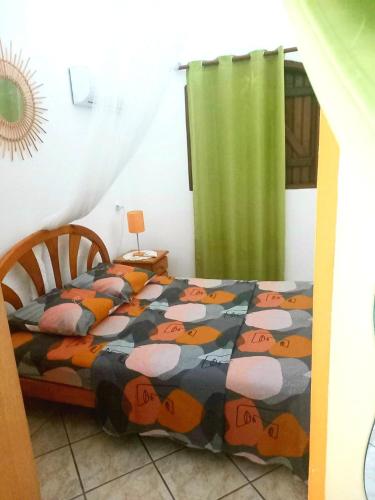 a bedroom with a bed with a pumpkin comforter at Chez Liliane in Bouillante