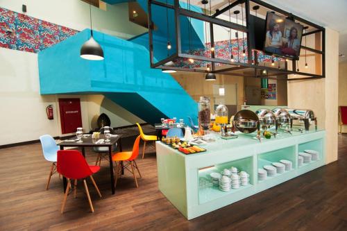a dining room with a table and a blue kitchen at Idoop Hotel by Prasanthi in Mataram