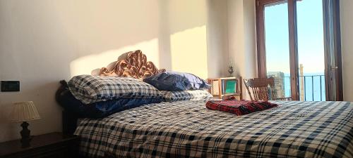 a bed with a checkered blanket and two pillows on it at TakeAmalfiCoast Main House in Minori