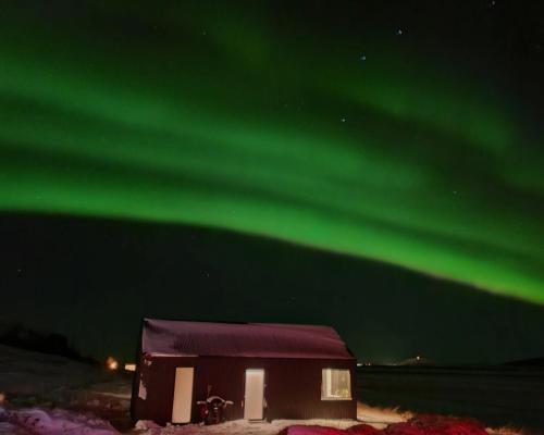 a house with the aurora in the sky at Svartaborg in Húsavík