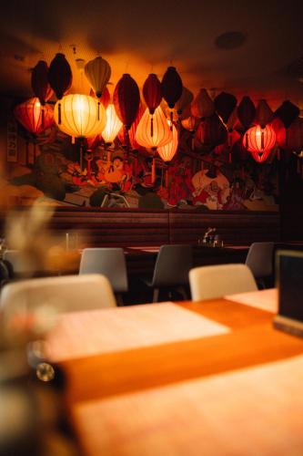 a room with tables and chairs and lanterns on the wall at Me and All Hotel Dusseldorf, by Hyatt in Düsseldorf