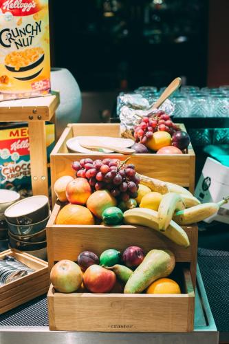 three wooden boxes filled with different types of fruit at Me and All Hotel Dusseldorf, by Hyatt in Düsseldorf