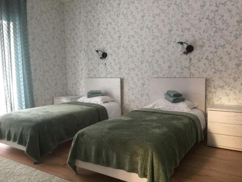 a bedroom with two beds with green blankets at Allika külalistemaja 