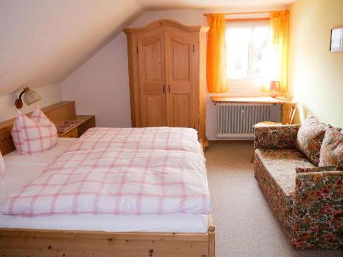 1 dormitorio con cama, sofá y ventana en Gästehaus Lickert Familie Dreher, en Hinterzarten