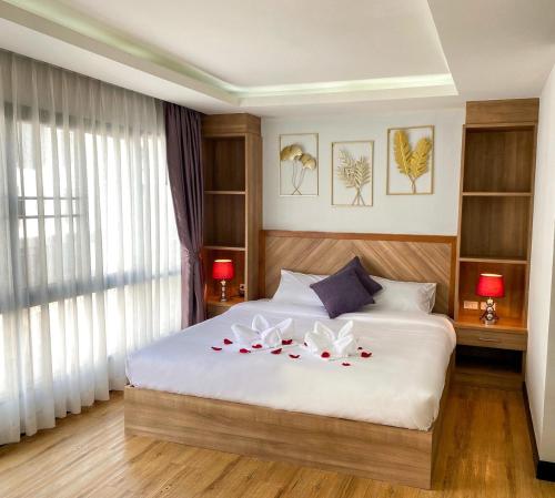 a bedroom with a white bed with flowers on it at DE LUXE BOUTIQUE & rooftop in Chiang Mai