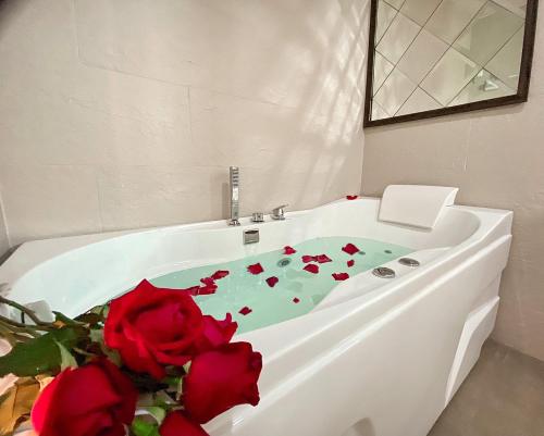 a bath tub with red roses sitting in it at DE LUXE BOUTIQUE & rooftop in Chiang Mai