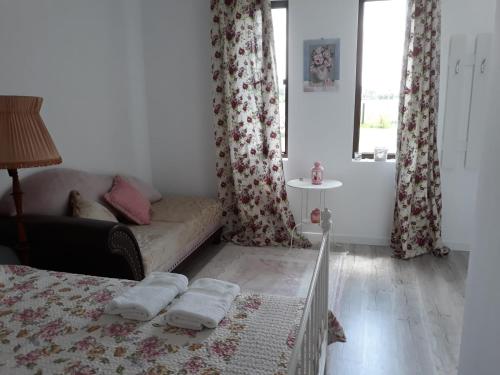 ein Schlafzimmer mit einem Bett, einem Sofa und einem Fenster in der Unterkunft Garden Pypa in Vânătorii Mici