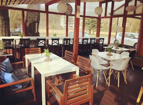 a restaurant with tables and chairs and a clock at Alba Hotel in Jūrmala