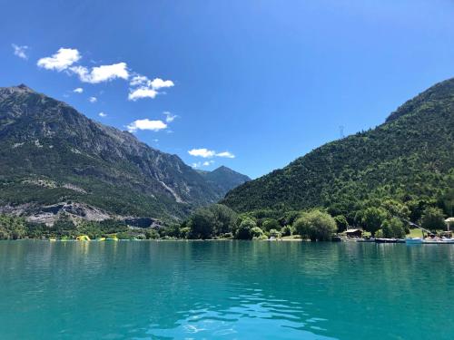 une vue d'un lac avec des montagnes en arrière-plan dans l'établissement Camping le Lac, à Le Villard