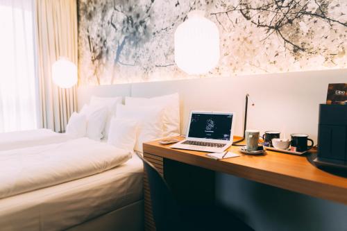 a hotel room with a bed and a laptop on a desk at Me and All Hotel Dusseldorf, by Hyatt in Düsseldorf