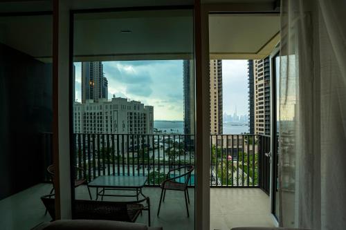 a room with a balcony with a view of the city at Magnolia- Dubai Creek Harbour Condo Apartment ApartHotel UAE in Dubai