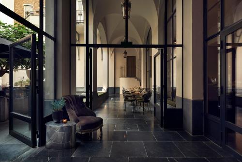 a hallway of a building with a table and chairs at The Dominican, Brussels, a Member of Design Hotels in Brussels