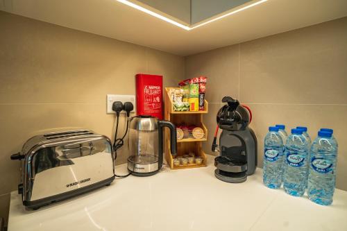 a kitchen counter with a toaster and water bottles at Magnolia- Dubai Creek Harbour Condo Apartment ApartHotel UAE in Dubai