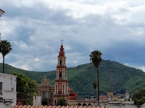 un edificio con una torre de reloj frente a una montaña en Departamento temporario en Salta la Linda en Salta