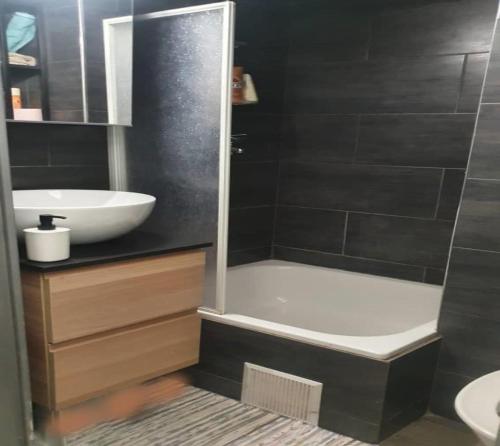 La salle de bains est pourvue d'un lavabo, d'une baignoire et de toilettes. dans l'établissement Apartment at Paris-Defense Arena Free parking by Servallgroup, à Courbevoie