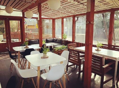 a covered patio with tables and chairs and a couch at Alba Hotel in Jūrmala