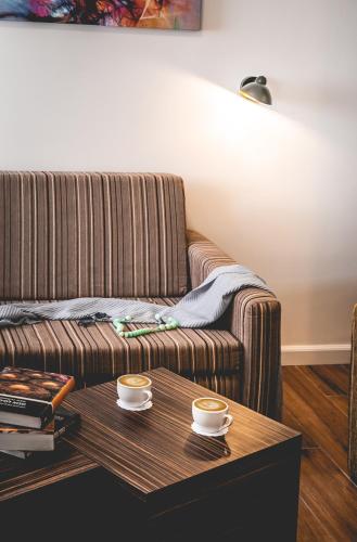 a living room with a couch and two cups on a table at Nof Tavor Hotel in Mizra‘
