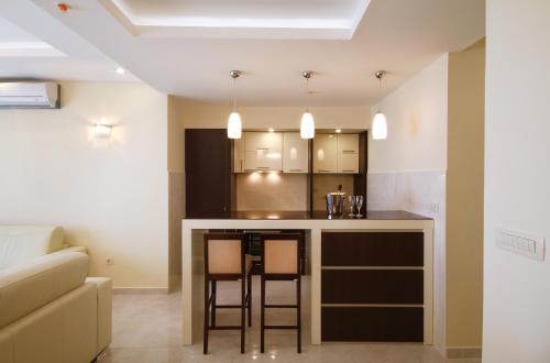 a kitchen with a bar with two stools at Shine residence in Budva