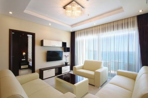 a living room with two white couches and a television at Shine residence in Budva
