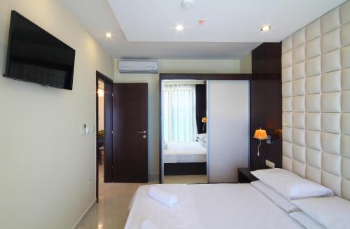 a bedroom with a white bed and a television at Shine residence in Budva