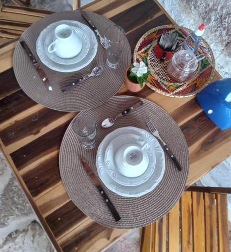 a table with two plates and a cup and aucer at CASA TRILHAS DE IGATU - CHAPADA DIAMANTINA - BAHIA in Igatu