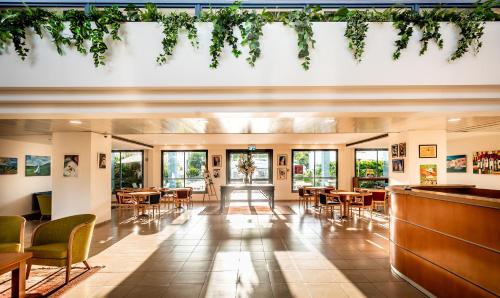 a restaurant with tables and chairs and a bar at Nof Tavor Hotel in Mizra‘