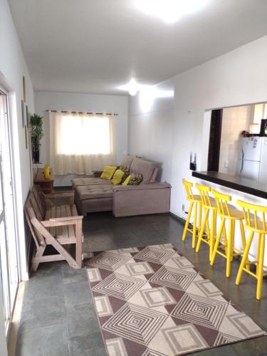 Apartamento Cobertura في ساو بيدرو دا ألديا: غرفة معيشة مع أريكة وكراسي صفراء