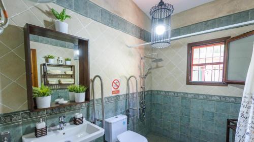 a bathroom with a sink and a toilet and a mirror at Villa Solgor Benamocarra by Ruralidays in Las Zorrillas