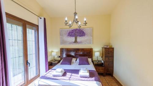 a bedroom with two beds and a painting on the wall at Villa Solgor Benamocarra by Ruralidays in Las Zorrillas