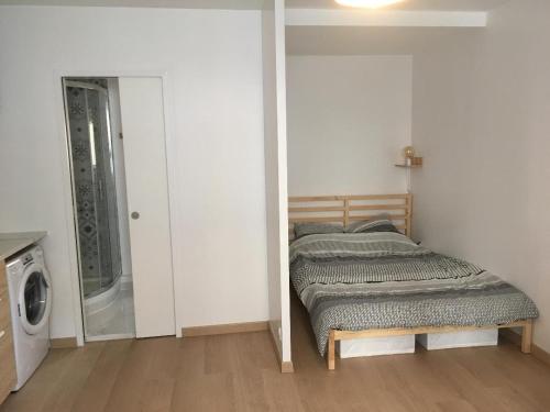 a bedroom with a bed and a washing machine at Chez Simon et Loreline Yerres proche Paris Orly Disney in Yerres