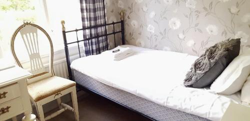 a small bedroom with a bed and a chair at Huskvarna Hotell & Vandrarhem in Huskvarna