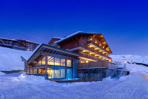 a building on top of a snow covered mountain at Ours Blanc Hotel & Spa in Les Menuires