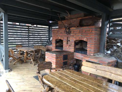 a brick fireplace with a wooden table and a bench at BrickWood in Verkhniy Koropets