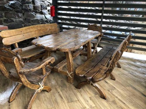 a wooden table with two chairs and a wooden bench at BrickWood in Verkhniy Koropets