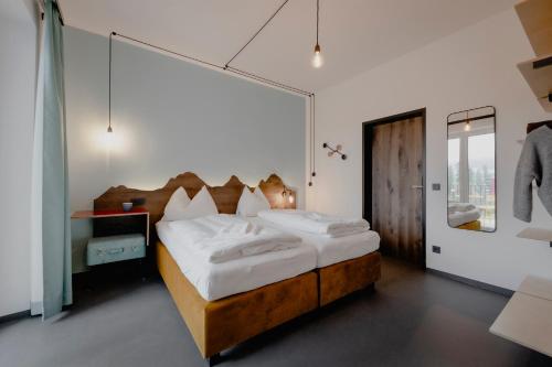 a bedroom with a large bed with white sheets at Bett & Berg Bad Ischl, Self Check-In in Bad Ischl