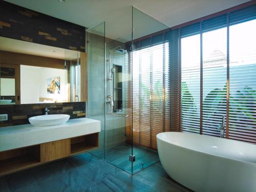 a bathroom with a tub and a sink and a mirror at Bliss Villa at Shambhala Grand in Bang Tao Beach
