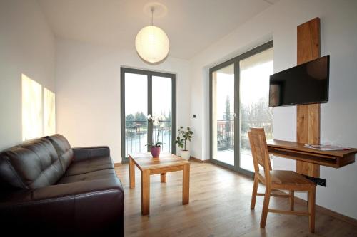 a living room with a couch and a table and a desk at FerienRemise in Brandenburg an der Havel