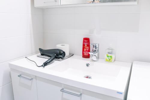 a white bathroom counter with a hair dryer on it at City center 1R studio with perfect view, parking in Oulu