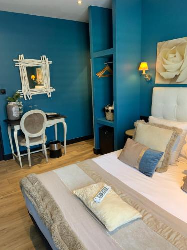 Schlafzimmer mit blauen Wänden, einem Bett und einem Schreibtisch in der Unterkunft Be Cottage Hotel in Le Touquet-Paris-Plage