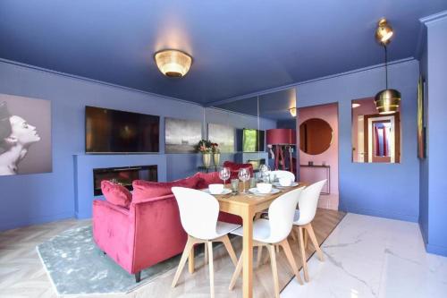 un salon avec un canapé rose et une table dans l'établissement luxury Paris La Vie En Rose jacuzzi terrasse Parking, à Paris