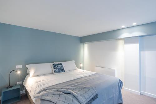 a bedroom with a large bed with a blue wall at Suite Tigli - by MyHomeInComo in Como