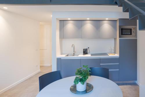 a kitchen with blue cabinets and a table with a potted plant at Suite Tigli - by MyHomeInComo in Como